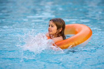 Little boy with rubber ring in swimming pool. Summertime fun. Little kid swimming in pool. Kid in swimming pool. Kid relax swim on inflatable ring. Summer vacation concept.