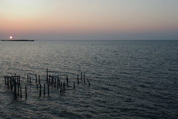 Sunrise overlooking Fishing dock in Cedar Key Florida. On a sunny day with calm waters. Wood pier...