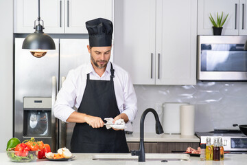 Chef mature man cook wear apron in kitchen. Handsome man preparing food in kitchen. Guy cooking a tasty meal. Man on kitchen with meat and vegetables. Portrait of casual guy in apron in kitchen.