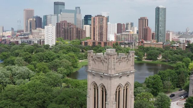 Aerial close-up parallax panning shot around the belltower at Saint Mark's Episcopal Cathedral with the Minneapolis skyline in the background. 4K