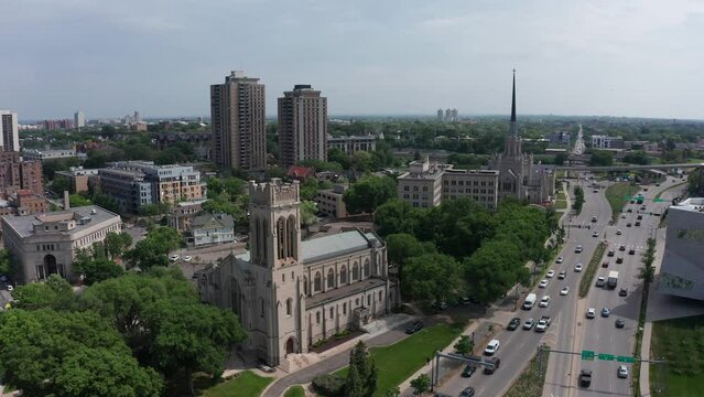 Wide rising and panning aerial shot of Saint Mark's Episcopal Cathedral and a United Methodist church in downtown Minneapolis, Minnesota. 4K