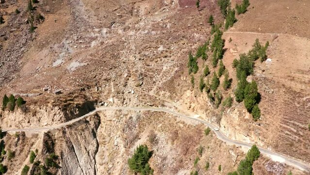 Vehicle Driving On Narrow Mountain Road Along Himachal's Sangla Valley In India. aerial