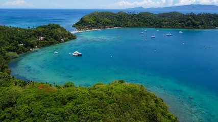 Fototapeta premium View of island. Tropical landscape. Sailing yachts in the bay. Aerial view of the bay and coast of a tropical island.