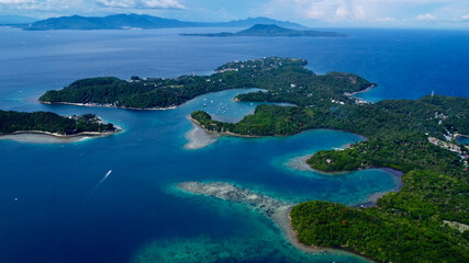 View of the sea and mountains. Tropical landscape. Aerial view of a tropical island. The coast of the island with small bays and straits. Boats are moving in the bay.