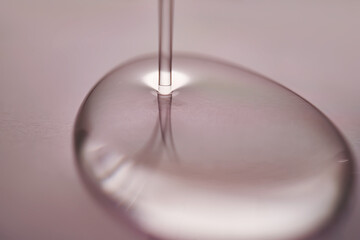 A juicy drop of gel on a purple background.