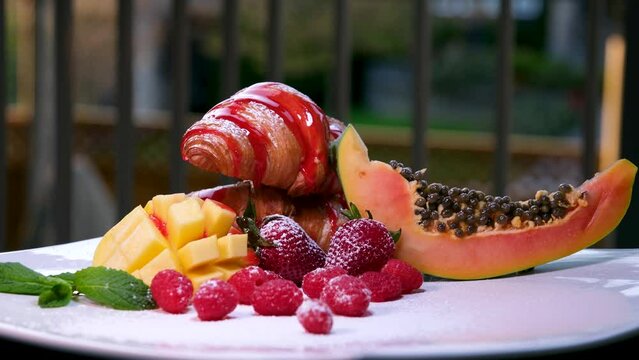 croissant drizzled with delicious strawberry raspberry syrup Heaped fruit on white plate appetizing dessert lunch snow healthy food french restaurant cooking indulge in anything