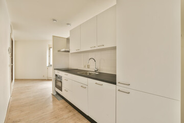 an empty kitchen with white cabinets and black counter tops on the floor in a new apartment...