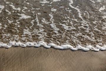 Ocean waves on a wet sandy beach
