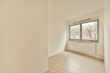 an empty room with wood floors and white walls, there is a large window in the wall to the right