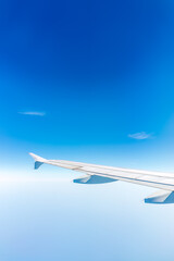 View from the airplane window at a beautiful cloudy sky and the airplane wing