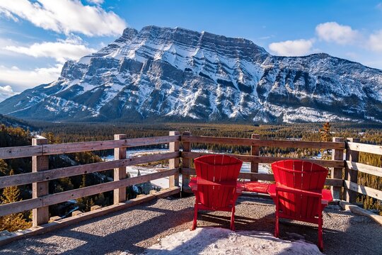 Red Adirondack Chairs Looking Out Over Wintry Mountains