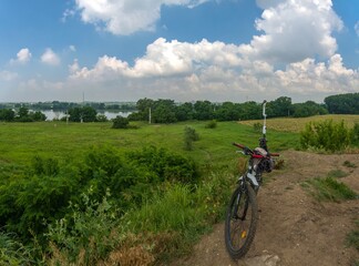 shooting a panorama of the outskirts of the city near the river with a smartphone mounted on a gimbal, which is fixed on the seat of a bicycle - a sunny summer day