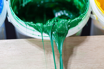 .Green paint dripping from white barrel..plastisol ink is used for printing on fabrics because it...