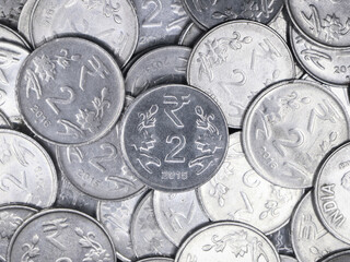 closeup of a collection of indian 2 ( two ) rupee coins made of silver in a mixed up pile 