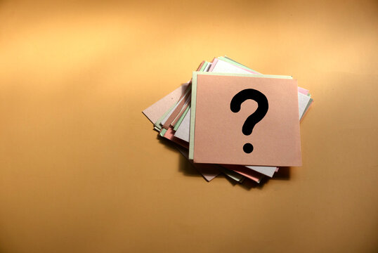 Questions and answer concept. Question mark written on paper. Brown silhouette shadow background.