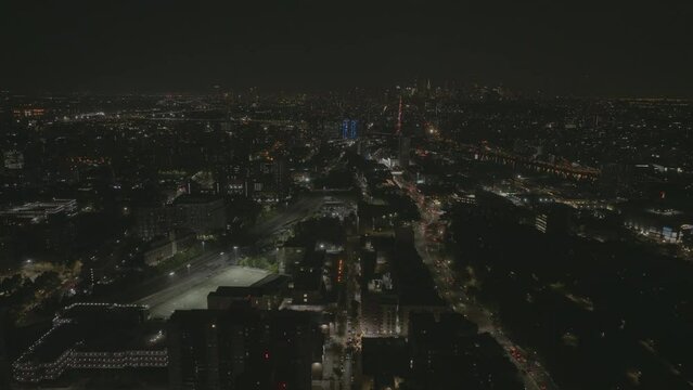 Drone shot over Bronx cityscape, toward Mott Haven, nighttime in New York, USA