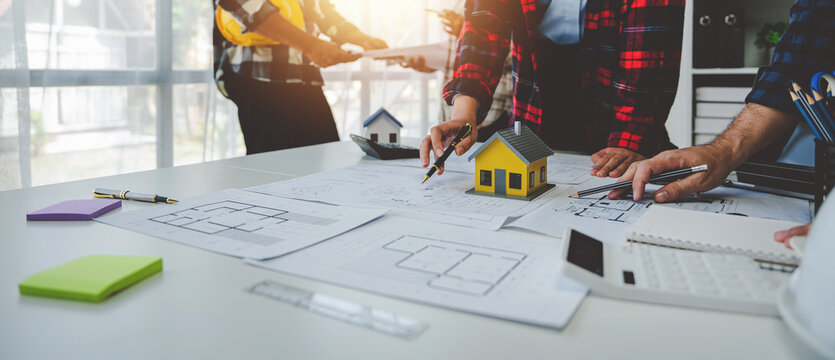 Engineers work as a team with blueprints for architectural plans. Engineer sketching construction project concept with architect equipment Architects talking at table Teamwork and construction concept
