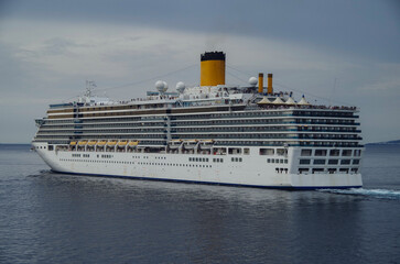 Modern white cruiseship or cruise ship liner Deliziosa in port of Mykonos, Greece during Mediterranean Greek Island cruising to Med for dream holiday vacation	