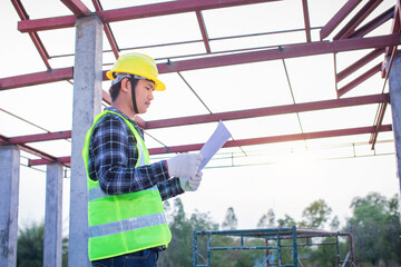 An engineer is looking at and inspecting the unfinished roof construction drawings.