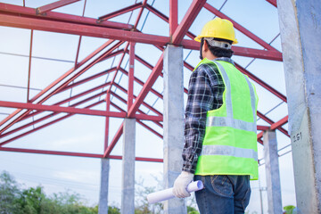 An engineer looks at the roof of an unfinished house and considers the work of the carpenter.