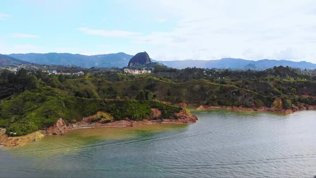 Aerial near El Peñón de Guatapé, a large and unique stand alone rock with stairs to the top and featuring panoramic views, Guatapé, Colombia. Drone  dolly forward