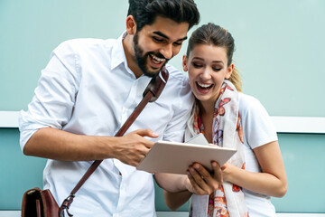 Happy couple in love using digital devises for work, study or social media.