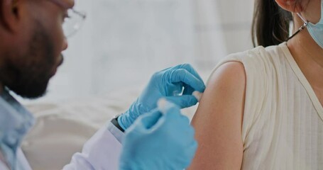 Young african american male doctor injecting flu or corona virus vaccine for female patient in a health clinic. Medical nurse use hypodermic needle and a syringe put shot of drug for treatment. - Powered by Adobe