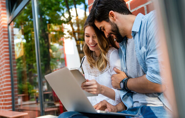 Happy young couple working studying on laptop and digital devices. Business education people concept