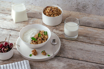 granola in a bowl with yogurt and fresh cherries