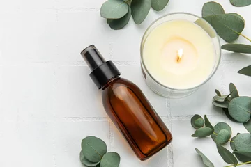 Papier Peint photo Salon de massage Bottle of natural cosmetic oil, aroma candle and eucalyptus leaves