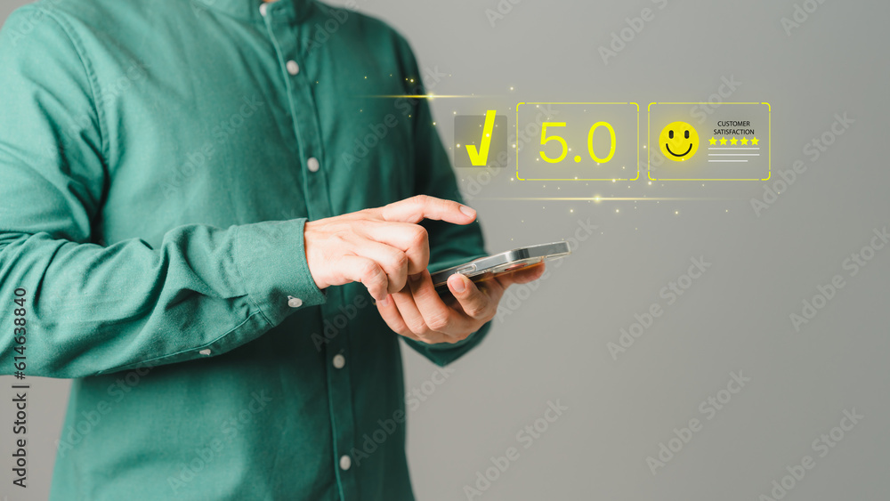 Poster Customer using a mobile phone to rate service satisfaction with virtual screens on smile face icon. Comment scores are very impressive. Customer service assessment, testimonial, and feedback.