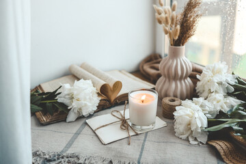 Burning candle and white peonies, vintage aesthetic