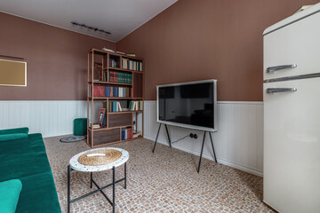 Stylish living room in house with modern retro interior design, velvet sofa, plants, poster mock up map, book, lamp and perosnal accessories in home decor.