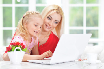 mother and daughter using laptop