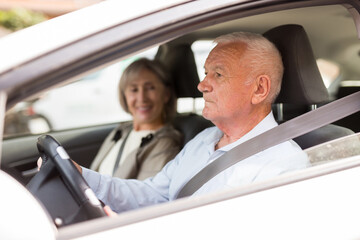 Caucasian senior couple sitting in car. Old man sitting on driver's seat.