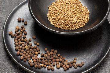 Allspice on black porcelain plate.