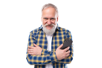 Fototapeta premium handsome 50s elderly gray-haired man with a beard masters a smartphone on a white background