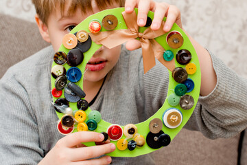 Advent wreath made by kid from old buttons and paper.
