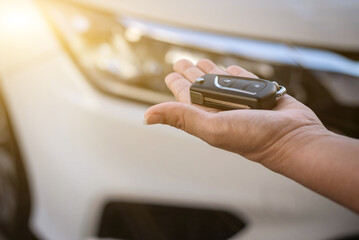 Remote key of a white car in young woman's hands