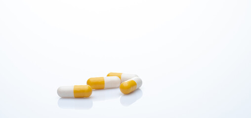 Yellow-white probiotic capsule pill on white background. Probiotic supplement. Gut health. Dietary supplements. Probiotics for a healthy gut. Lactobacillus acidophilus and Bifidobacterium animalis.