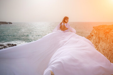 Woman sea white dress. Happy freedom woman on the beach enjoying and posing in white dress. Rear view of a girl in a fluttering white dress in the wind. Holidays, holidays at sea.