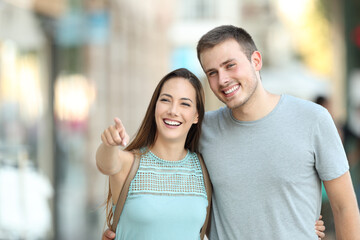 Fototapeta premium Happy couple pointing something in the street