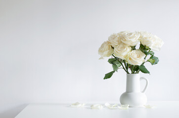 bouquet of white roses in jug on white background