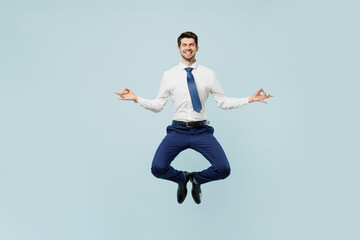 Full body young employee IT business man corporate lawyer in classic formal shirt tie work in office spread hand in yoga om aum gesture relax meditate try calm down isolated on plain blue background