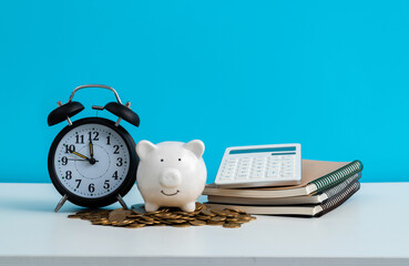 Alarm clock and piggy bank on office table