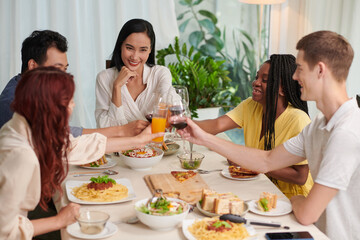 Obraz na płótnie Canvas Happy group of friends toasting over dinner table