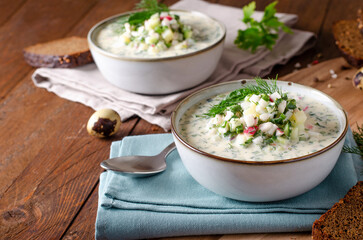 Cold Okroshka Soup with Eggs, Vegetables, Meat, Herbs and Kefir on a Wooden Background, Summer Soup