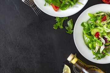 Top view two plates of fresh diet salad on dark background with copy space, delicious healthy food