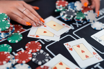 close-up female player are taking chips from the poker table at casino