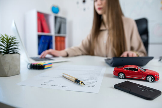 A saleswoman advises a client about selling or renting a car in the office
